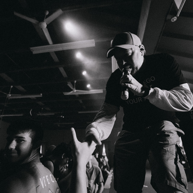 Sam Llanes performing live, reaching toward the audience